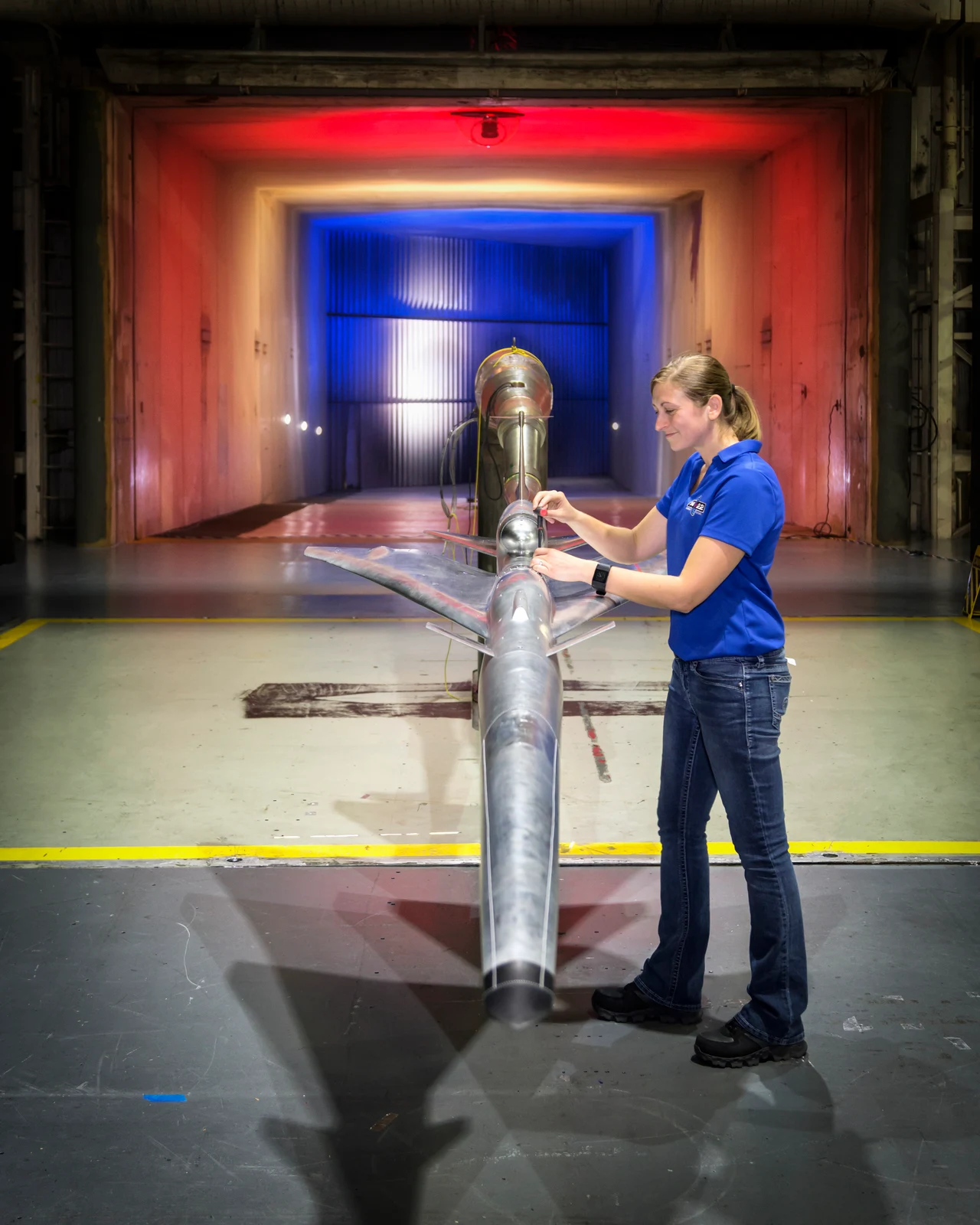 NASA engineer inspecting a scale aircraft model in a wind tunnel