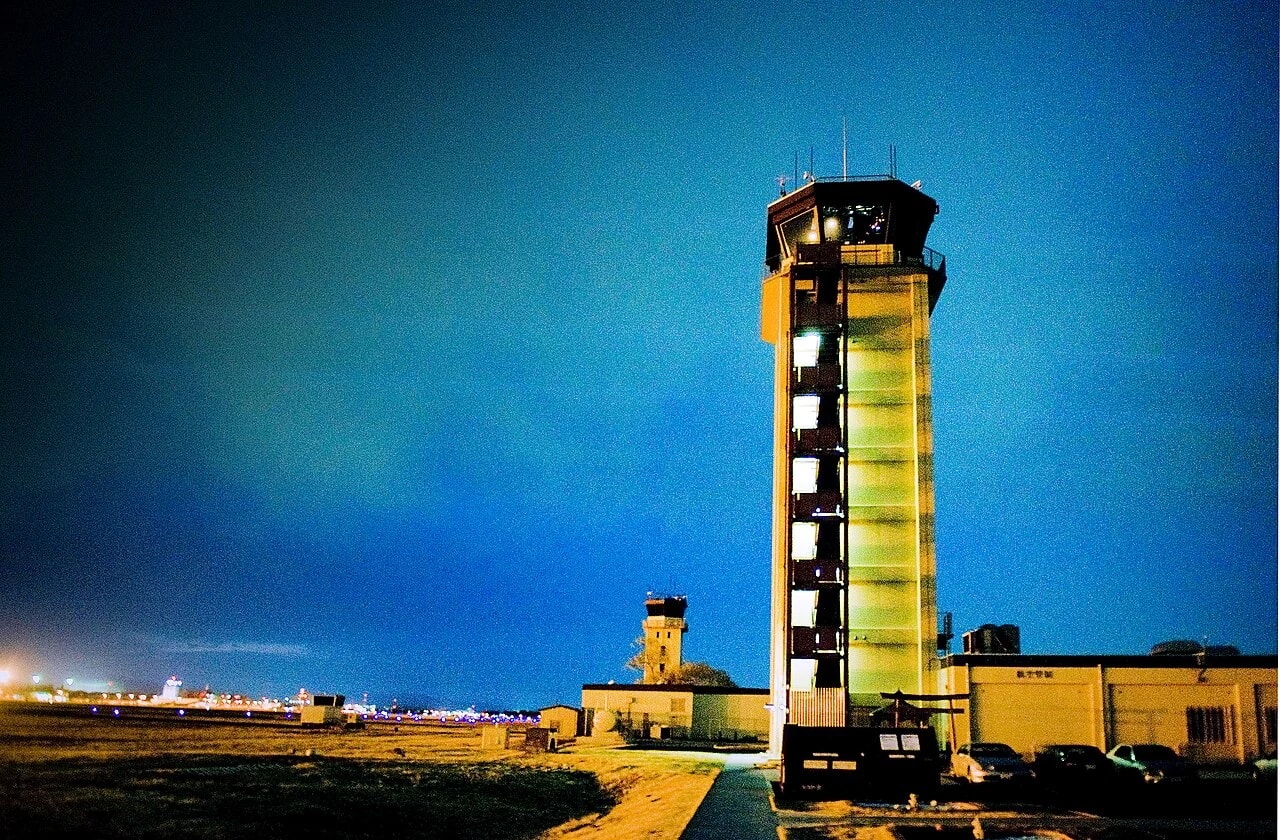 Illuminated air traffic control tower overlooking an airfield